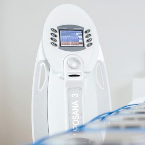 Das weiße Spa- oder Medizingerät mit der Aufschrift „CAROSANA 3“ verfügt über einen Touchscreen mit Bedienelementen, der sich perfekt für Behandlungen wie Pediküre oder Haarentfernung eignet. Im Vordergrund ist deutlich ein blaues Kabel zu erkennen.